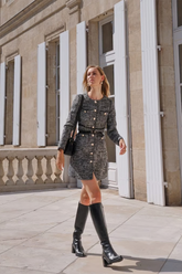a lady wears a mini tweed dress with black knee high boots